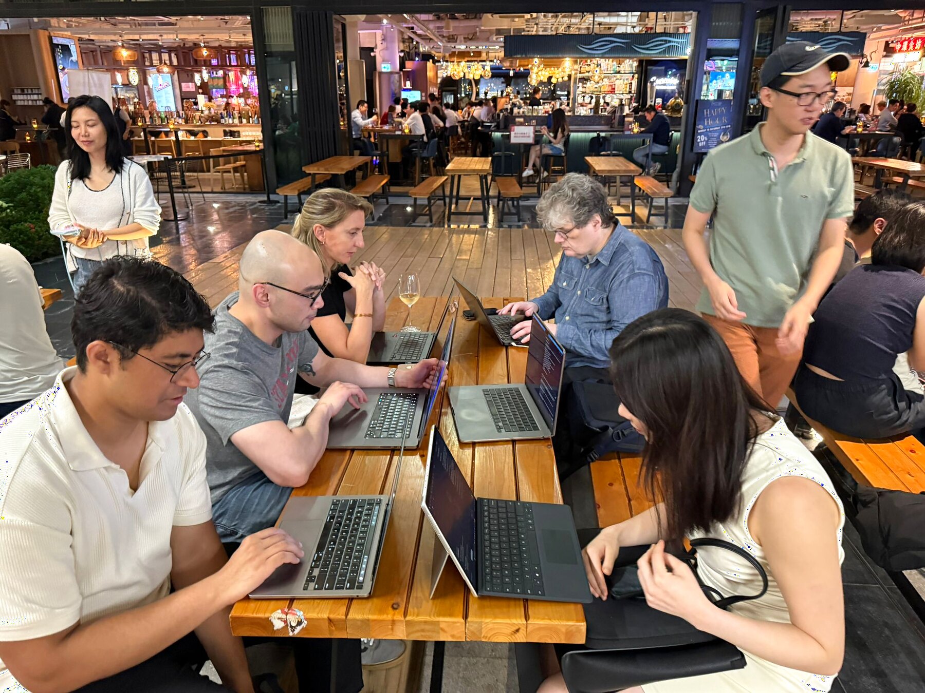 Attendees working through Cursor prompts around a wooden table