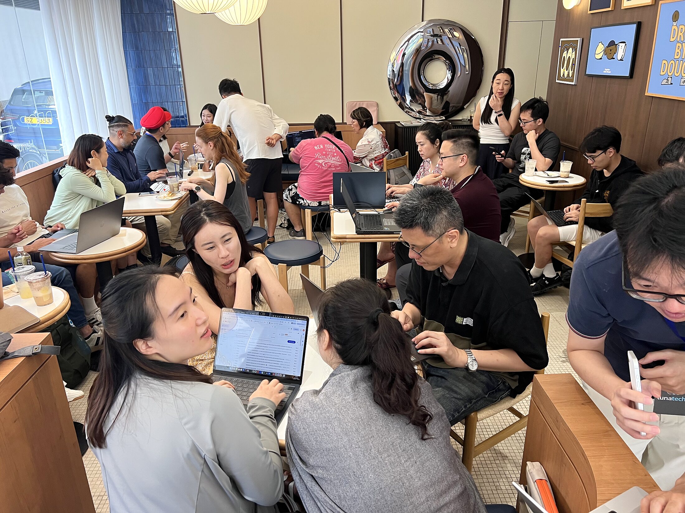 Drop By Dough filled with builders working at small tables during the DeepSeek OpenCode session